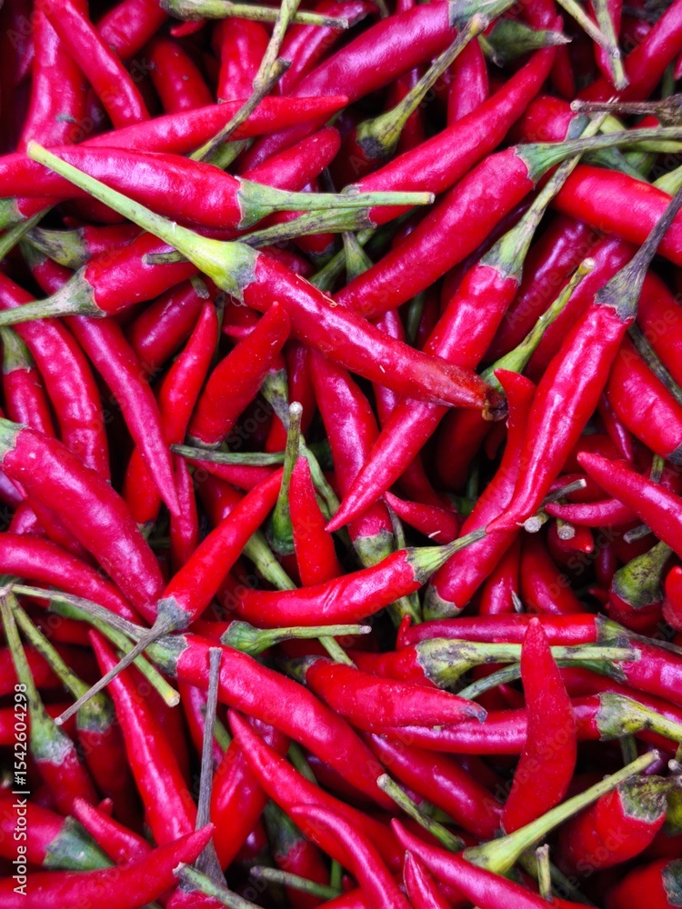 A substantial heap of bright red hot peppers, emphasizing their fiery appearance and fresh quality A substantial heap of bright red hot peppers, emphasizing their fiery appearance and fresh quality