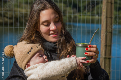 Cute baby trying to drink his mother's chimarrão (mate).