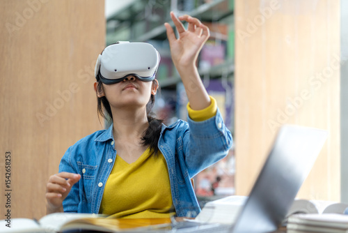 A young woman wearing a VR headset interacts with virtual content while studying in a library