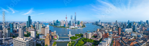 Panoramic Aerial view of Shanghai skyline and winding river on sunny day.