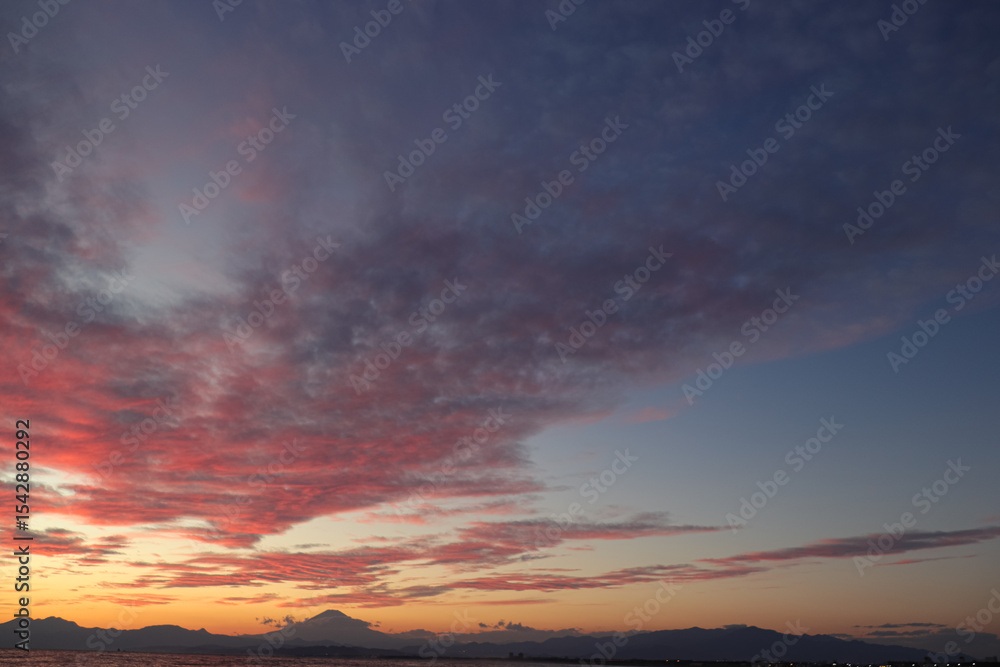 Fototapeta premium A scenic view of a sunrise or sunset, with warm tones painting the sky. Perfect for use as background material, evoking calm, beauty, and inspiration.