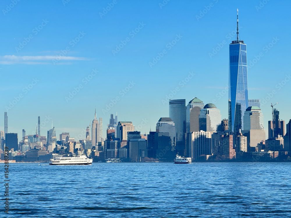 Obraz premium Manhattan buildings and an island ferry. From Ellis island.