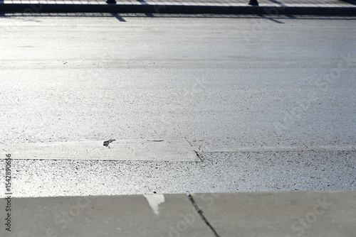 concrete and asphalt road surface with a crack