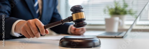 Judge's gavel held aloft in a courtroom setting.