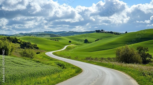 The serene landscape features a curvy road nestled amidst gentle hills.