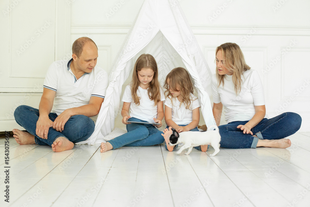 Fototapeta premium Happy family mother father and children using tablet gadget sitting on floor at home