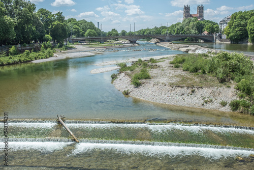Ausblick von Corneliusbrücke in München  auf die Isar mit  Stauwehr und Kiesbänken, Reichenbachbrücke und Kirche mit zwei Türmen