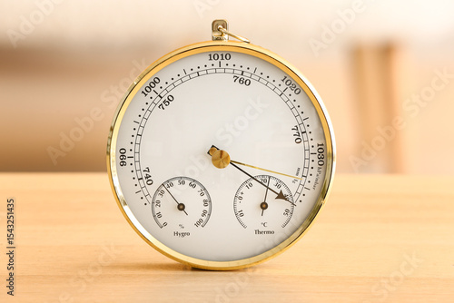 Aneroid barometer on wooden table in room, closeup