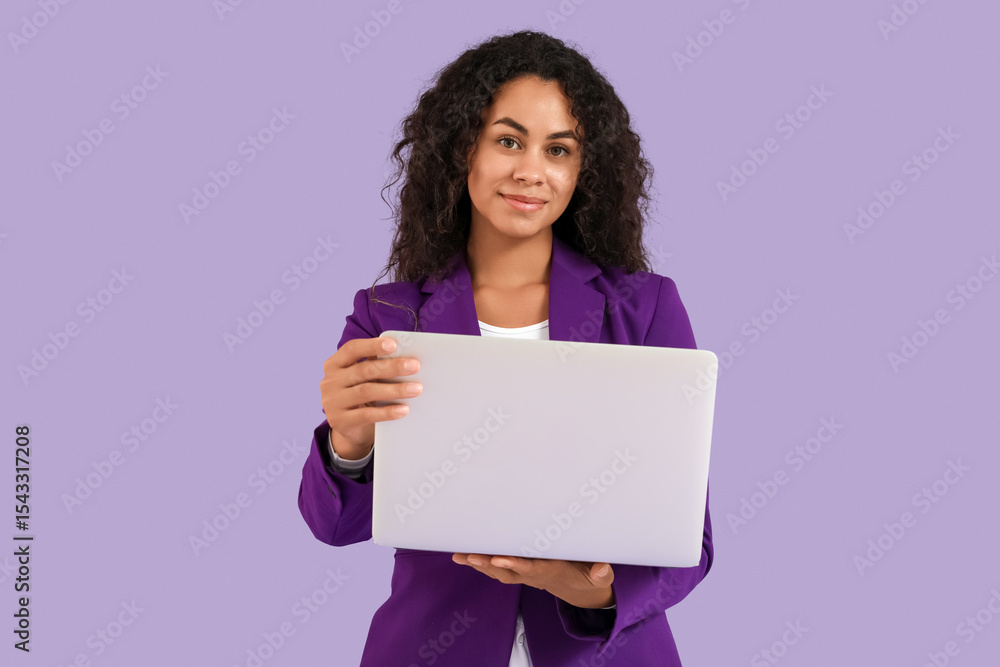Portrait of beautiful African-American businesswoman with laptop on purple background Portrait of beautiful African-American businesswoman with laptop on purple background