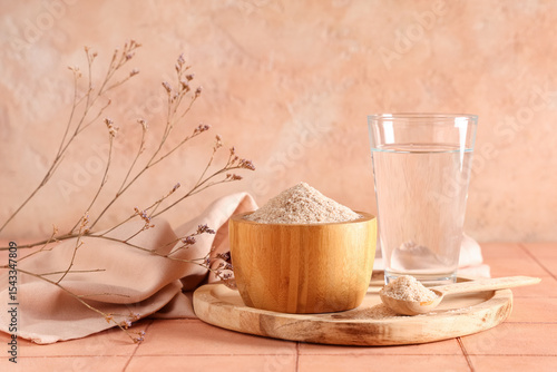 Fotografi Bowl with psyllium husk powder and glass of water on table