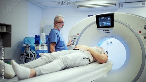 Doctor operationg CT machine in hospital.