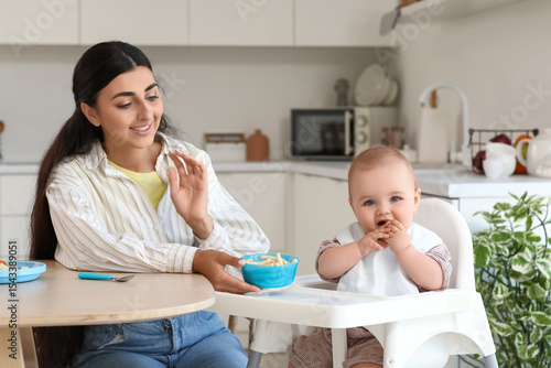 Mother feeding her baby wit...