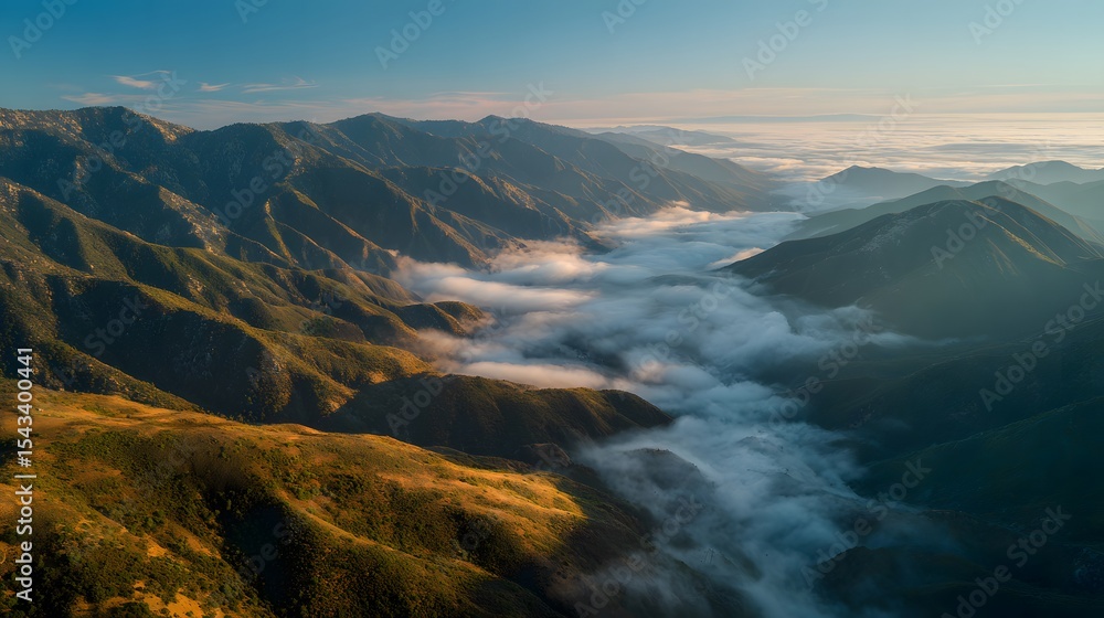 Fototapeta premium Aerial view of mountain range landscape with clouds and blue sky scenery shot