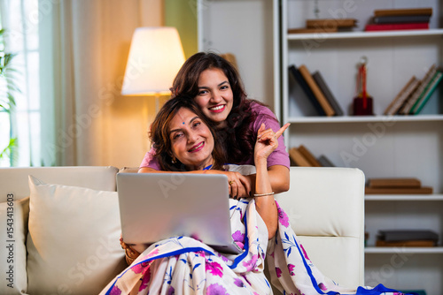 Photography Senior mother and young daughter surfing internet together on laptop with joy an