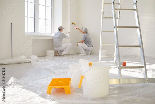 Fotografie Painters team working with paint rollers, construction workers, professional ser