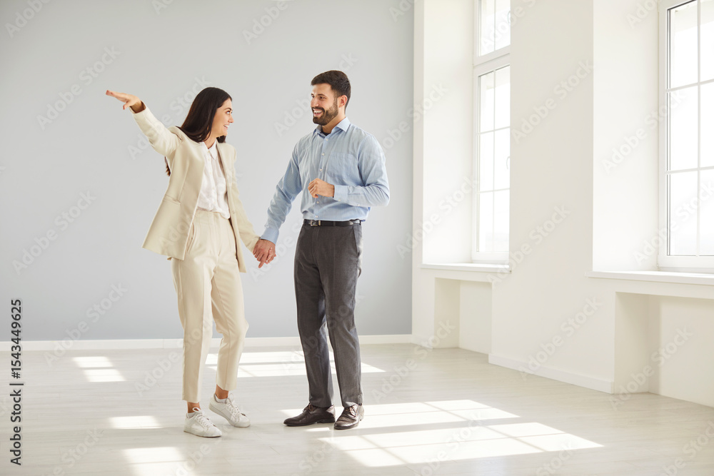Fototapeta premium Cheerful family couple celebrating house ownership by dreaming about living space and planning future together in new home. Reflects teamwork, hope, and the joy of starting a new chapter.