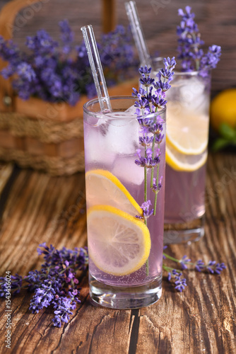  A glass of homemade lavender lemonade. Garnished with lemon wedges and lavender sprigs