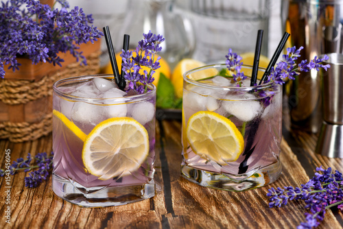 Margarita cocktail with lavender flavor. Garnished with lemon wedges and lavender sprigs