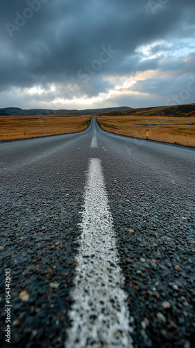 Wallpaper Mural Solitary Road:  A long road stretches to the horizon beneath a dramatic sky. An asphalt path across an open landscape. Torontodigital.ca
