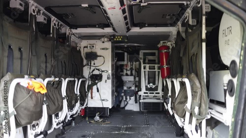Interior of armored personnel carrier with tactical seats cables and emergency gear captures raw utilitarian military design ready for rapid troop deployment or battlefield transport