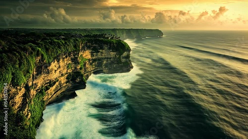 Dramatic coastal cliffs meet crashing waves at sunset