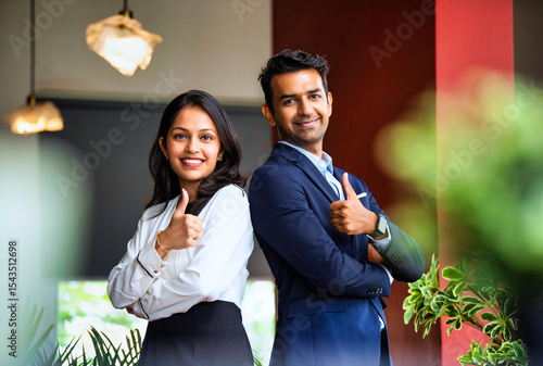 Posing with success and smiling confidently, Indian business professionals stand in office together