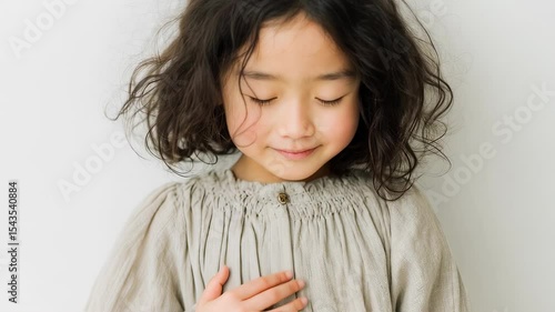 目を閉じて静かに祈る子供の姿