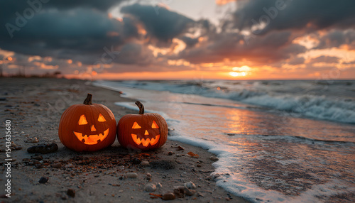 Fototapeta Naklejka Na Ścianę i Meble -  Jack-o'-lantern pumpkins on a sandy beach at sunset