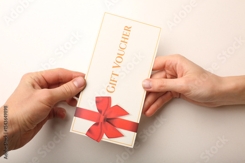 Top view of woman holding gift voucher with 500 value lettering on white background