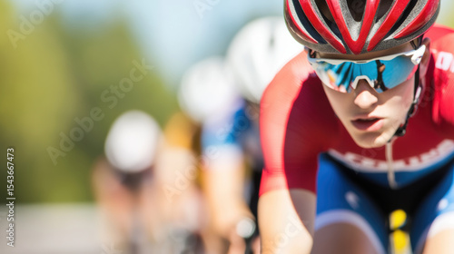 Group of young athletes competing in track cycling event, showcasing determination and speed. focus is on cyclist wearing red jersey and sunglasses, emphasizing competitive spirit