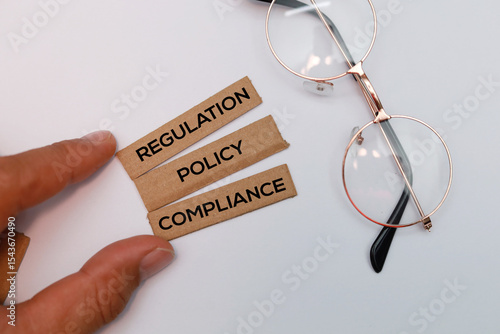 Hand holding a stick with the three words regulation policy and compliance the ethical concept