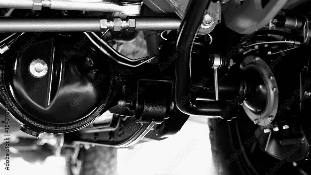 Obraz premium Car suspension part. Close up of a rear car suspension and exhaust system. such as coil springs link arms axle housing and performance exhaust. For auto engineering or car suspension part industry use