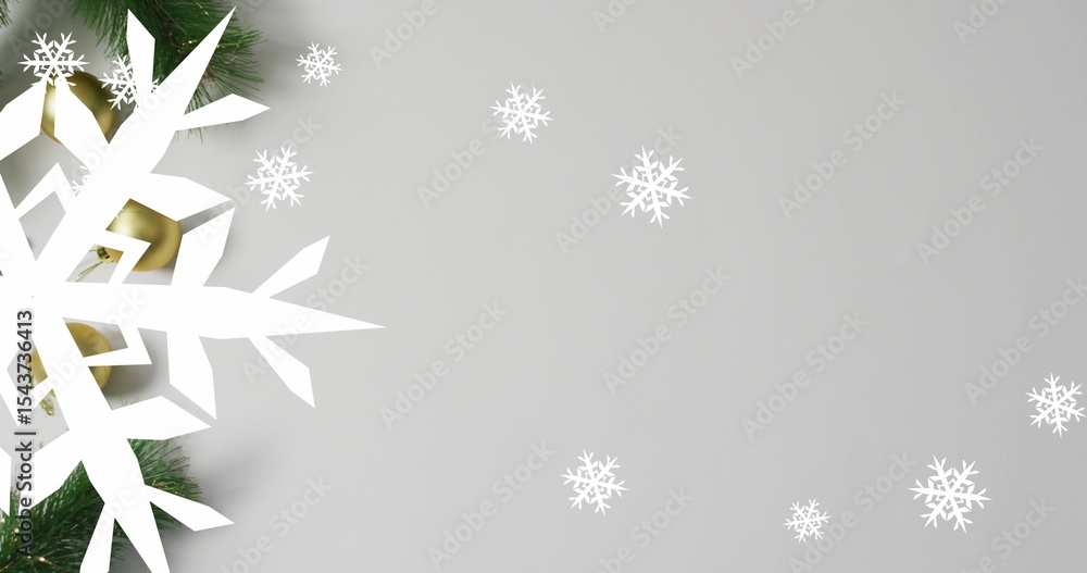 Obraz premium Arranging white snowflake cutout pine branches and golden ornament on gray backdrop, copy space