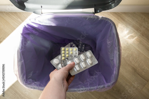 Tableau sur toile Female hand discarding blister packs into trash bin