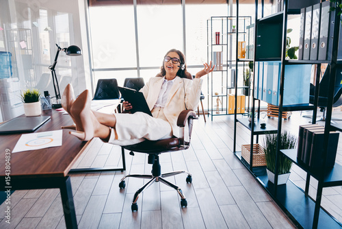 Tablou pe pânză Confident businesswoman relaxing in her office chair while working in a brightly