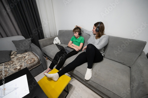 Canvas Print Engaging family time with a tech savvy kid and his focused mom in a cozy living