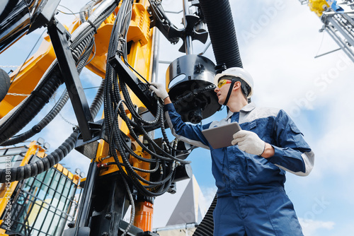 Foto Offshore worker inspect with tablet drilling rig for exploration of minerals for oil, gas