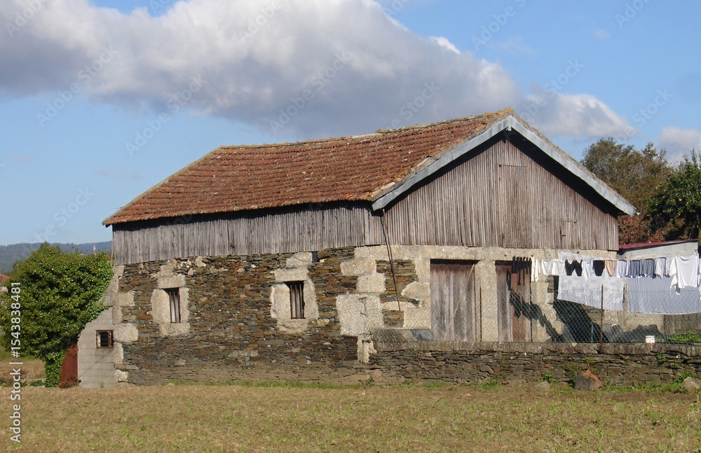 Obraz premium Old barn with clothes hanging and stone and wood facade in the countryside, Quintadona - Portugal 