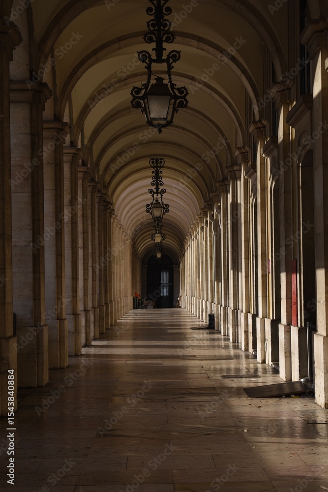 Fototapeta premium Symmetrical stone arcade with vaulted arches and shadows in Lisbon, Portugal