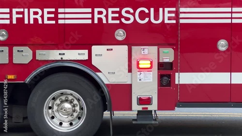 Looping close up of a red fire engine and rescue truck with flashing lights