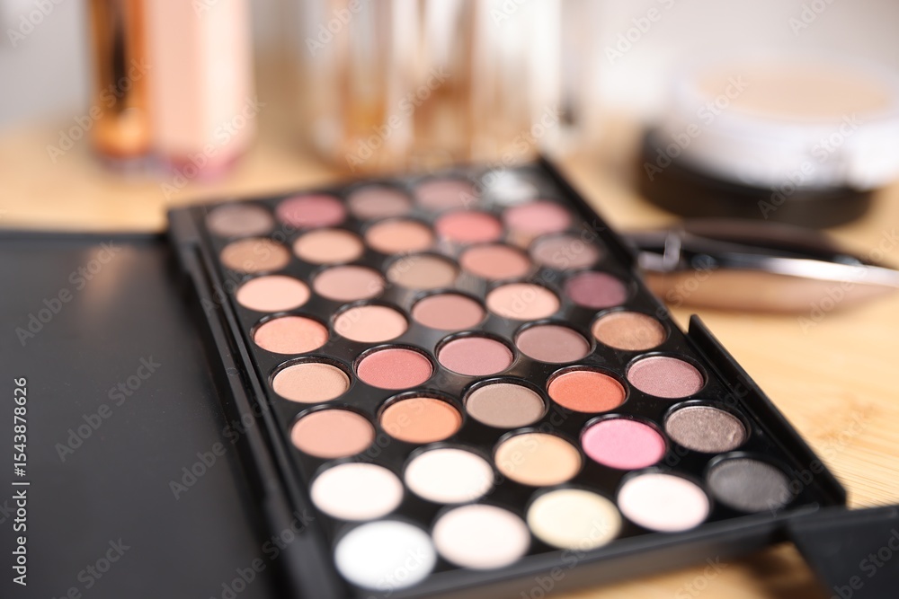 Different makeup products on wooden vanity indoors, closeup Different makeup products on wooden vanity indoors, closeup