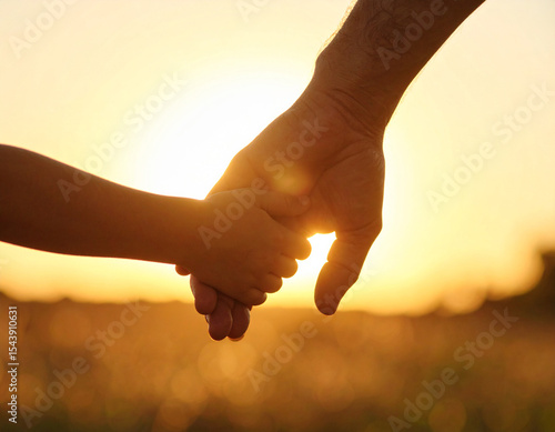 Silhouette of Adult and Child Holding Hands in Nature During Golden Hour, sunset
