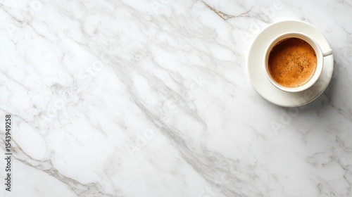 Elegant white marble surface with a cup of fresh brewed coffee in a white ceramic mug top view