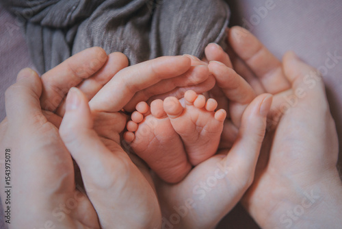 Mom's arms hug the baby. the legs of a newborn. the heels, the fingers of a baby, a child. Childbirth, maternity capital, artificial insemination, IVF, mortgage, family, love. High quality photo