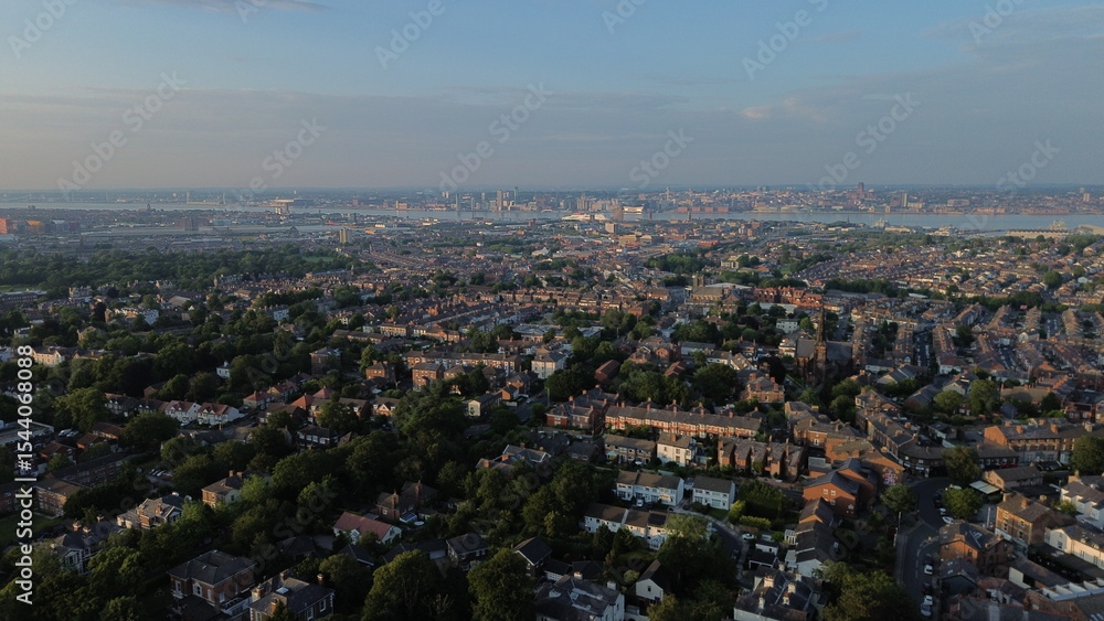 Obraz premium Aerial view of UK town in low sunlight depicting housing buildings near body of water.