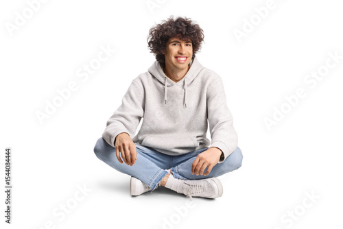 Quadro su tela Young man with curly hair sitting with crossed legs