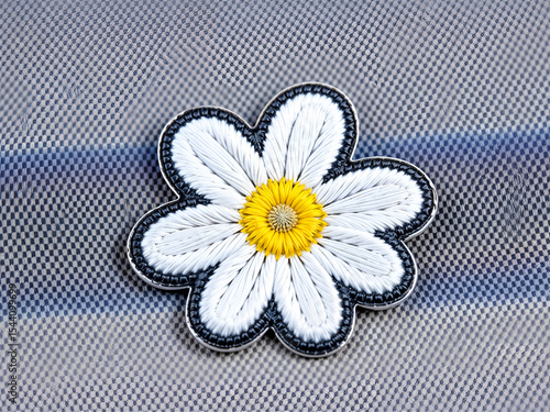 Embroidered white daisy patch with yellow center on striped fabric, perfect for clothing decoration or craft projects. Generative AI