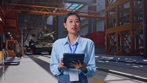 Wallpaper Mural Asian Female With Her Tablet, Military Tank Under Construction in Industrial Facility, She Observes By Looking Around Before She Come To Concentrating With Her Tablet Torontodigital.ca