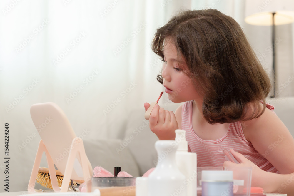 Young Asian girl applying lip gloss while looking into mirror, focused on beauty learning, nurturing self-confidence, joyful self-care moment during cozy home environment filled with love Young Asian girl applying lip gloss while looking into mirror, focused on beauty learning, nurturing self-confidence, joyful self-care moment during cozy home environment filled with love