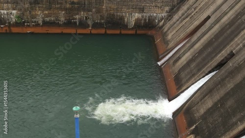 4k closeup shot, powerful water flows out of a large hydroelectric dam in India, captured from side as it surges through the discharge locks. Hadagarh Reservoir - Kendujhar, Odisha